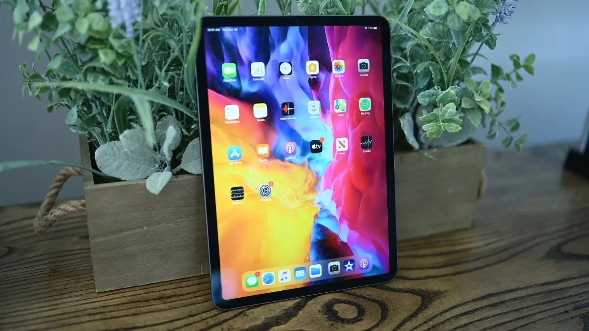 An ipad is sitting on a table next to a potted plant